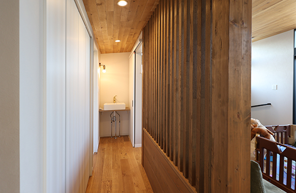 エナの家、アウトドアリビングスタイルのモデルハウス2階にあるスリット格子と手洗いスペース。